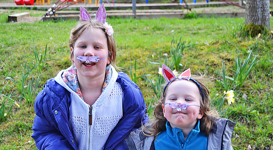 Zwei Kinder mit selbstgebasteltem Osterschmuck